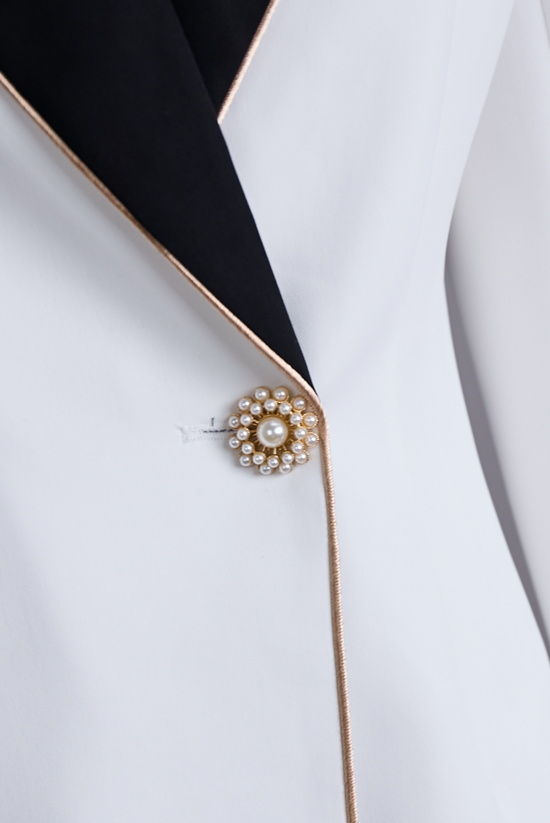 Blazer blanc asymétrique élégant avec revers noirs contrastés